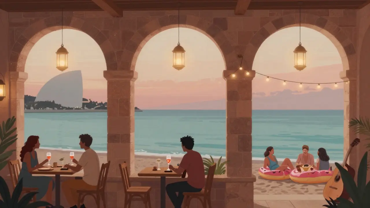 La Perle Beach at dusk with lanterns, couples drinking rosé, and acoustic music by the shore.